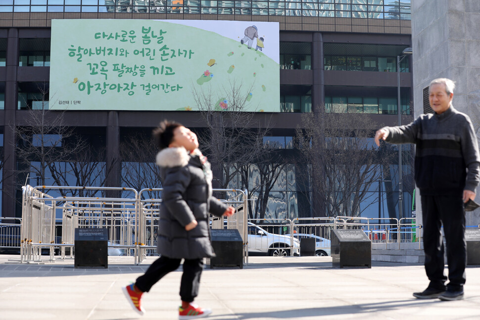 광화문 교보생명빌딩에 걸려있는 광화문글판 봄편 앞으로 한 어린이가 할아버지를 향해 뛰어가고 있다. 김혜윤 기자