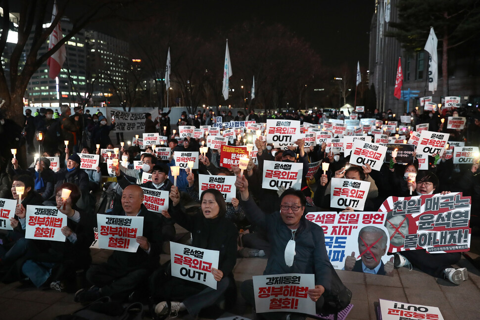 6일 저녁 서울시청 광장에서 ‘강제동원 정부해법 강행 및 친일 굴욕외교 규탄 긴급 촛불시위’가 열려 참가자들이 강제징용 노동자상 앞에서 손팻말과 촛불을 들고 있다. 윤운식 선임기자