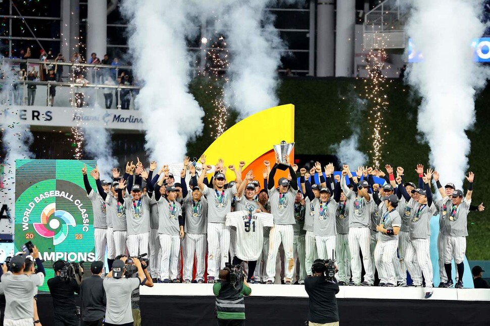 일본 선수들이 22일(한국시각) 미국 마이애미의 론디포 파크에서 열린 2023 세계야구클래식(WBC) 결승에서 미국을 꺾고 우승을 차지한 뒤 시상식 단상에서 좋아하고 있다. 51번 유니폼은 대회 직전 옆구리 부상으로 대표팀에서 낙마한 스즈키 세이야의 것이다. 마이애미/AFP 연합뉴스