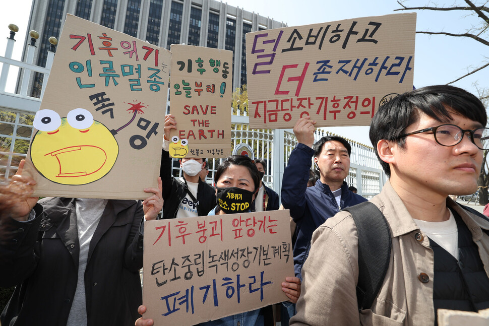 기후위기비상행동과 기후정의동맹, 민주노총과 한국노총 등 환경시민단체와 노동단체 관계자들이 10일 오후 서울 세종로 정부서울청사 앞에서 기자회견을 열어 ‘기후위기 역행하는 탄소중립 녹색성장 기본계획'을 폐기하고 재수립할 것을 촉구하며 손팻말을 들고 있다. 김정효 기자 hyopd@hani.co.kr