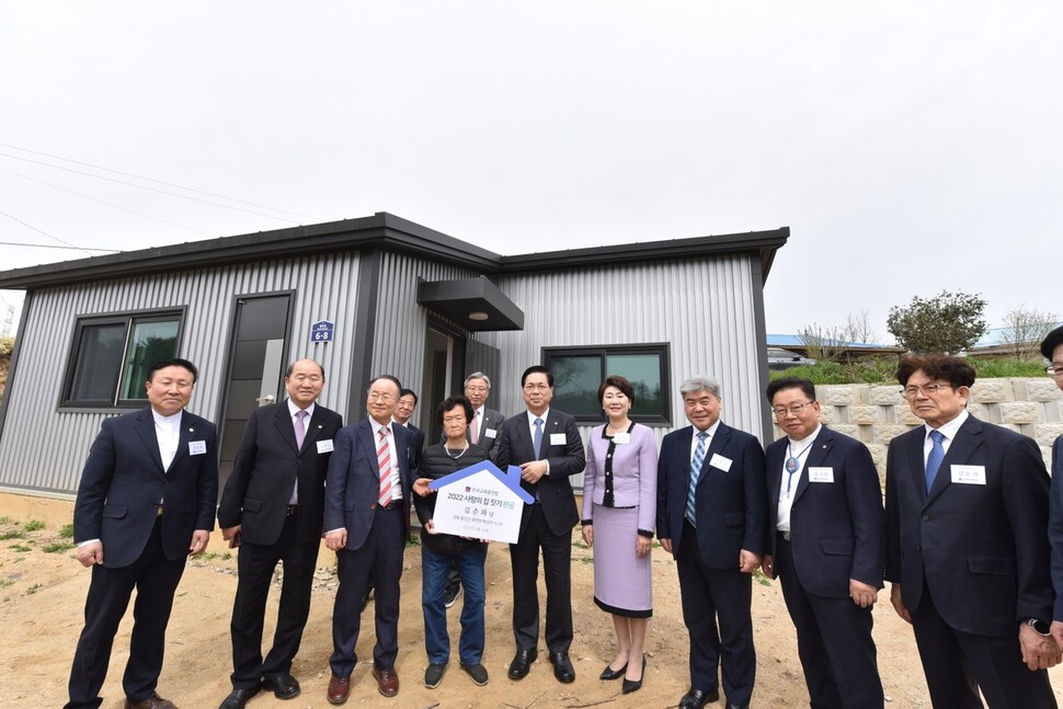 경북 울진 사랑의 집 짓기 현장에서 한교총 대표회장 이영훈 목사(왼쪽에서 5번째)와 한교총 전대표회장 류영모 목사(왼쪽에서 3번째)가 김춘화씨 집 앞에서 김씨를 축하해주고 있다. 사진 한교총 제공