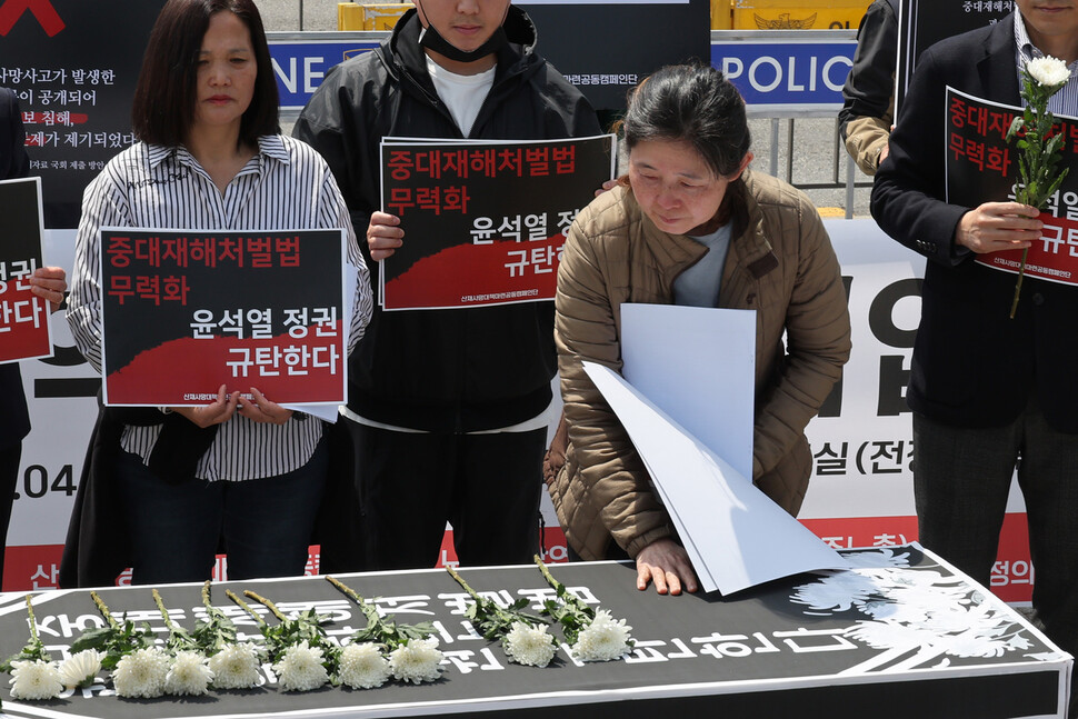 과로사로 아들을 잃은 박미숙씨가 산업재해로 사망한 사람들의 넋을 위로하는 상여 위에 국화를 올려놓고 상여를 쓰다듬고 있다. 김혜윤 기자