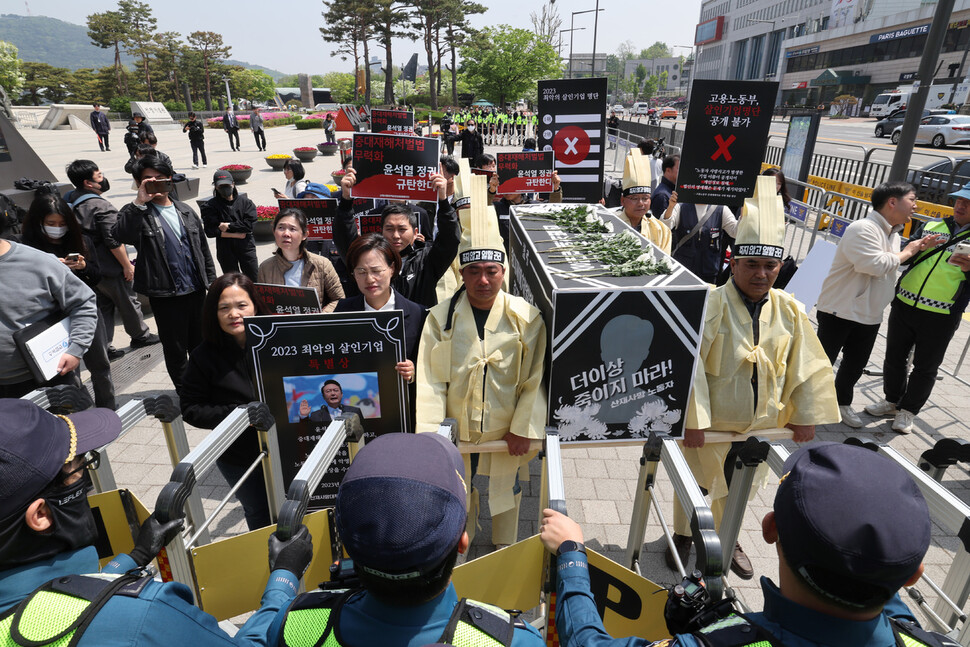 참석자들이 산업재해로 사망한 사람들의 넋을 위로하는 상여와 함께 윤석열 대통령에서 ‘2023 최악의 살인기업’ 특별상을 윤석열 대통령에게 전달하려 대통령실 방향으로 행진하자, 경찰이 저지하고 있다. 김혜윤 기자