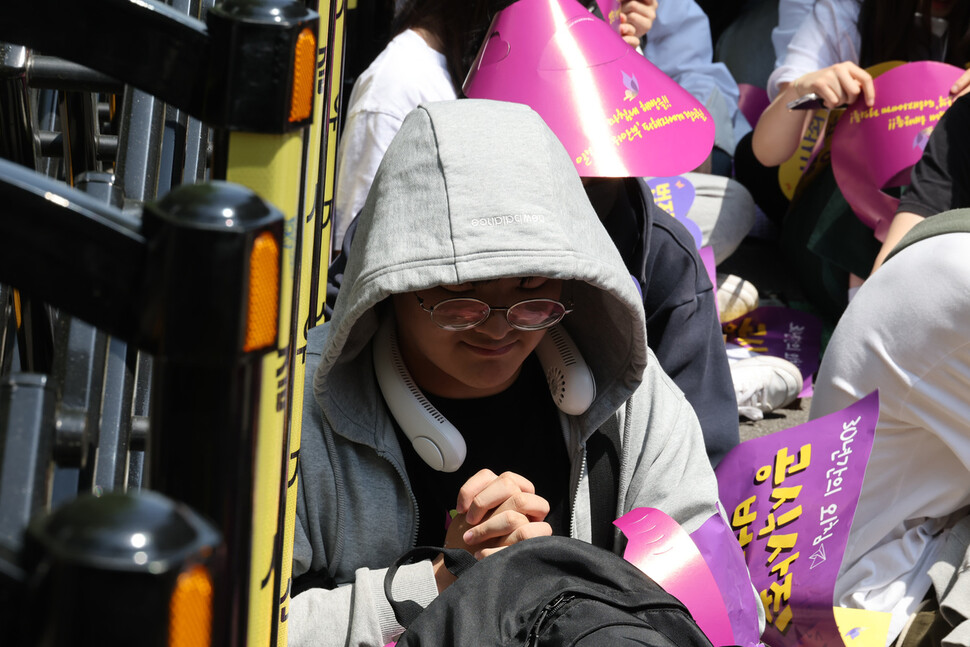 수요시위에 참석한 한 학생이 전날 별세한 일본군 ‘위안부’ 피해자 할머니를 위해 손을 모아 묵념하고 있다. 김혜윤 기자