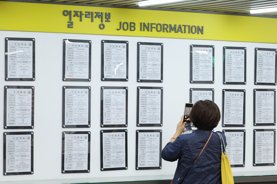 10일 서울 마포구 서부고용복지플러스센터에서 한 시민이 구인게시판 정보를 스마트폰 카메라에 담고 있다. 연합뉴스