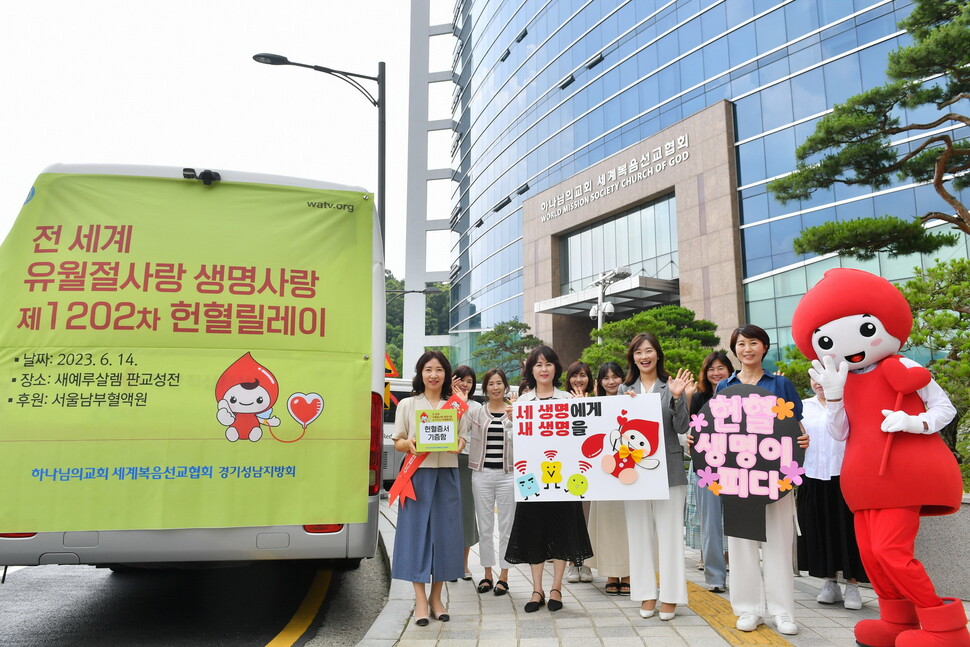 헌혈 참가자들이 헌혈의 중요성을 알려 '세 생명에게 새 생명을'이라고 쓴 손팻말을 들어보이고 있다.