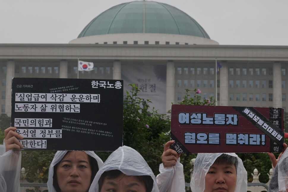 여성노동연대회의 활동가들이 국회 앞에서 손팻말을 들고 있다. 김혜윤 기자