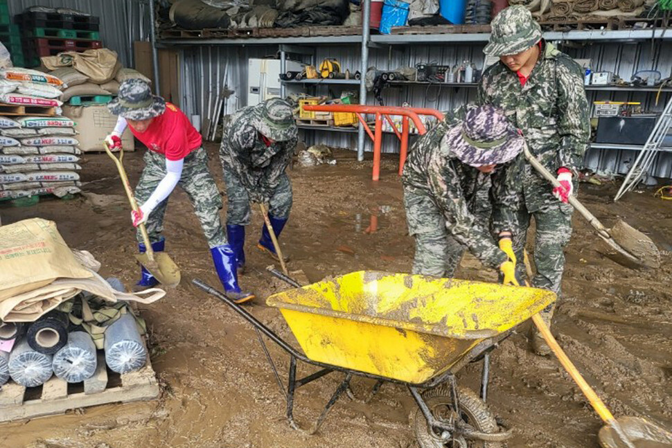 18일 경북 예천군 은풍면 동사리에서 해병대 신속기동부대 장병들이 침수가옥에 쌓인 진흙을 퍼나르며 복구작업을 벌이고 있다. 해병대 1사단 제공