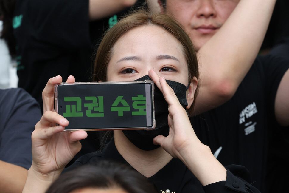 한 참석자가 핸드폰 화면에 구호를 띄우고 자유발언 하는 교사의 말에 호응하고 있다. 김혜윤 기자