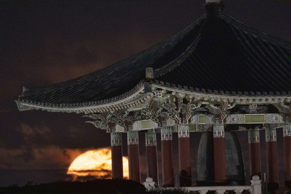 1일 미국 로스앤젤레스 샌 페드로 인근 엔젤스 게이트 공원에 있는 한국 우정의 종각 뒤로 철갑상어 슈퍼문이 떠오르고 있다. AP 연합뉴스