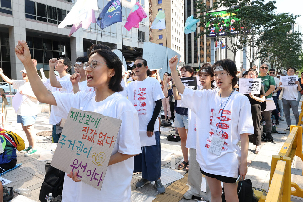 청년주거권실천단이 5일 오후 서울 중구 서울파이낸스센터 앞에서 열린 ‘불평등이 재난이다’ 반지하 폭우참사 1주기 추모문화제에서 구호를 외치고 있다. 단원들은 무더위를 피하기 위해 이마에 쿨패치를 붙이기도 했다. 백소아 기자