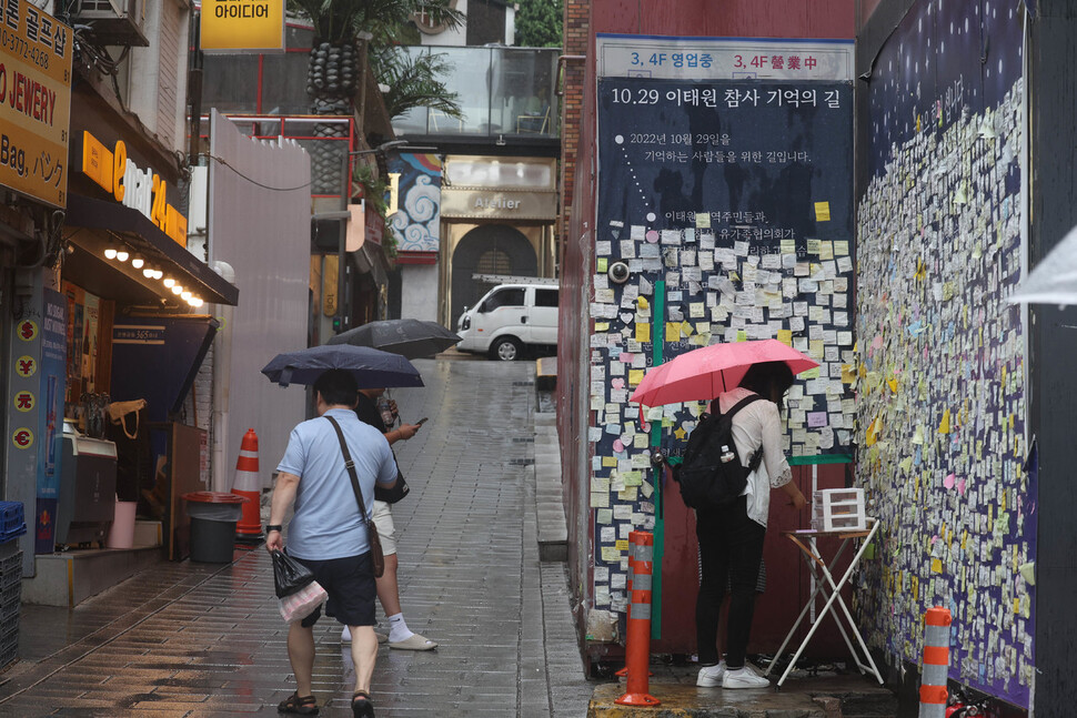 이태원 참사 발생 299일째인 23일 낮 서울 용산구 참사 현장 한 켠에 마련된 추모공간에서 외국인 관광객들이 추모메시지를 적고 있다. 백소아 기자 thanks@hani.co.kr