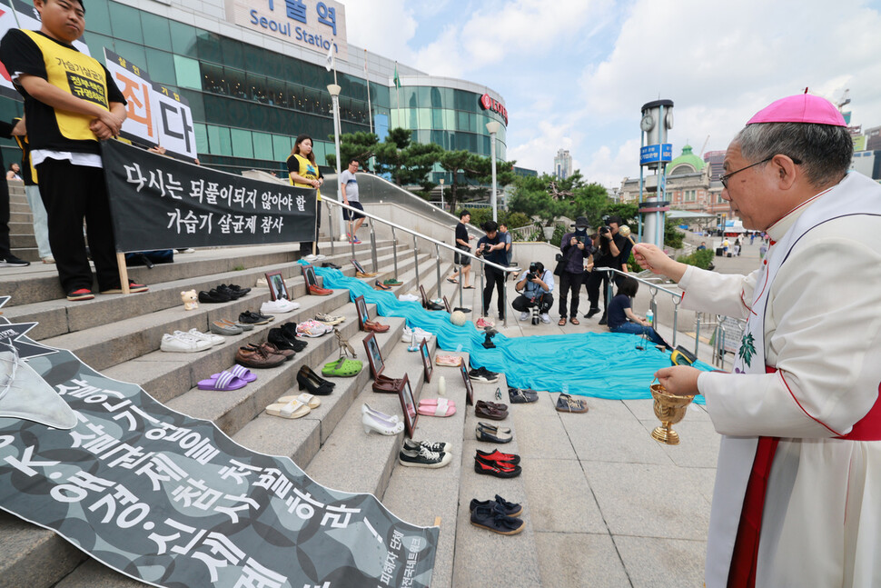 구요비 신부가 유품에 성수를 뿌리며 축복하고 있다. 김혜윤 기자