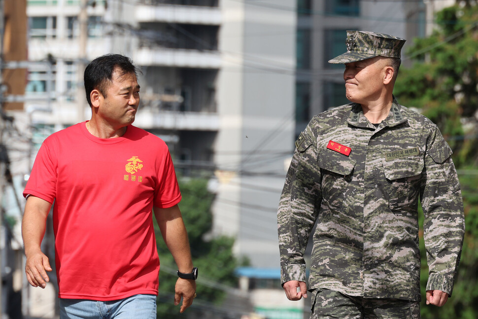 항명과 이종섭 국방부 장관에 대한 ‘상관 명예훼손’ 혐의를 받고 있는 박정훈 전 해병대 수사단장(대령)이 5일 서울 용산구 국방부 검찰단으로 출석하던 중 해병대 예비역 동기생과 마주보며 미소짓고 있다. 김혜윤 기자