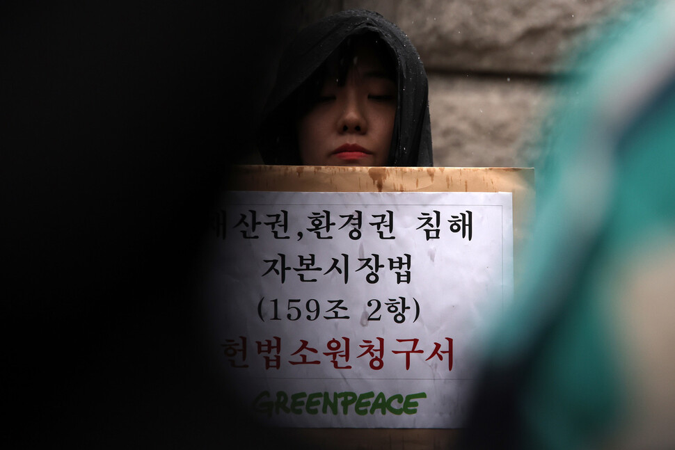 한 그린피스 활동가가 헌법소원 청구서가 담긴 봉투를 들고 있다. 김혜윤 기자