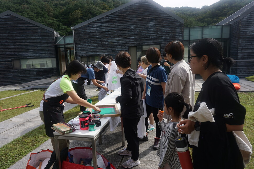 충남 공주 한국문화연수원에서 열린 ‘2023 솔라시포럼’ 이튿날인 22일 시민자치문화센터가 주관하는 ‘키후위키’가 ‘메시지를 입는다’는 이름으로 프로그램을 운영하고 있다. ‘날씨가 이상해’ 등의 메시지가 찍힌 중고 의류를 판매하고, 한쪽에서는 이러한 메시지를 중고 의류에 직접 실크스크린으로 찍어주는 이벤트를 진행했다.  ‘키후위키’는 기후위기, 차별, 젠더, 노동 등과 같은 현재 대두되고 있는 사회적 메시지를 수집하고 유쾌한 그래픽 디자인으로 표현하며 행동을 북돋는 메시지를 확산하고 있다.