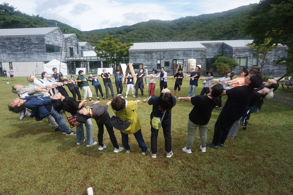 22일 오전 충남 공주 한국문화연수원에서 열린 ‘2023 솔라시포럼’ 중 ‘태화산과 마곡사 트래킹' 프로그램을 신청한 참가자들이 원형의 밧줄을 잡고 서로의 힘에 의지해 하늘을 바라보며 몸을 풀고 있다.