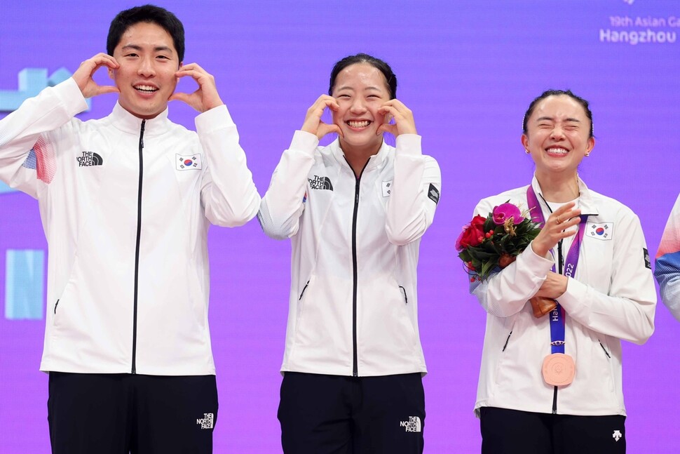 30일 열린 항저우아시안게임 탁구 혼합복식 시상식에서 신유빈(가운데)이 임종훈(왼쪽)과 함께 볼하트를 보여주고 있다. 오른쪽은 전지희. 대한탁구협회 제공