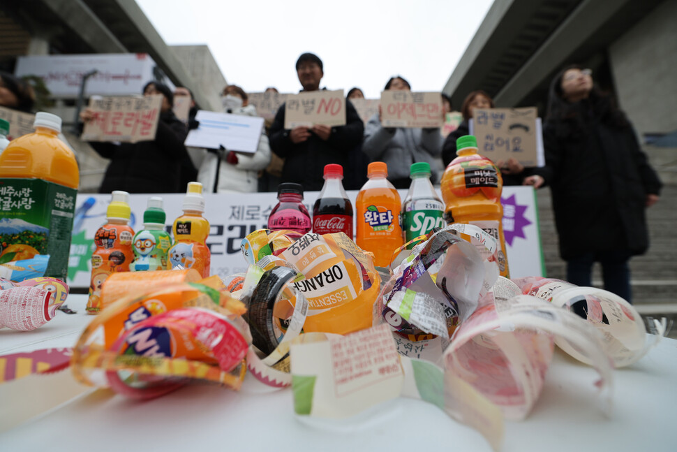 대구환경연합 자원순환프로젝트팀 ‘쓰레기고객센터’와 서울환경연합 활동가들이 29일 오후 서울 종로구 세종문화회관 계단에서 플라스틱 병입음료 제조사와 판매사에 무라벨 정책 도입을 촉구하고 있다. 김혜윤 기자 unique@hani.co.kr