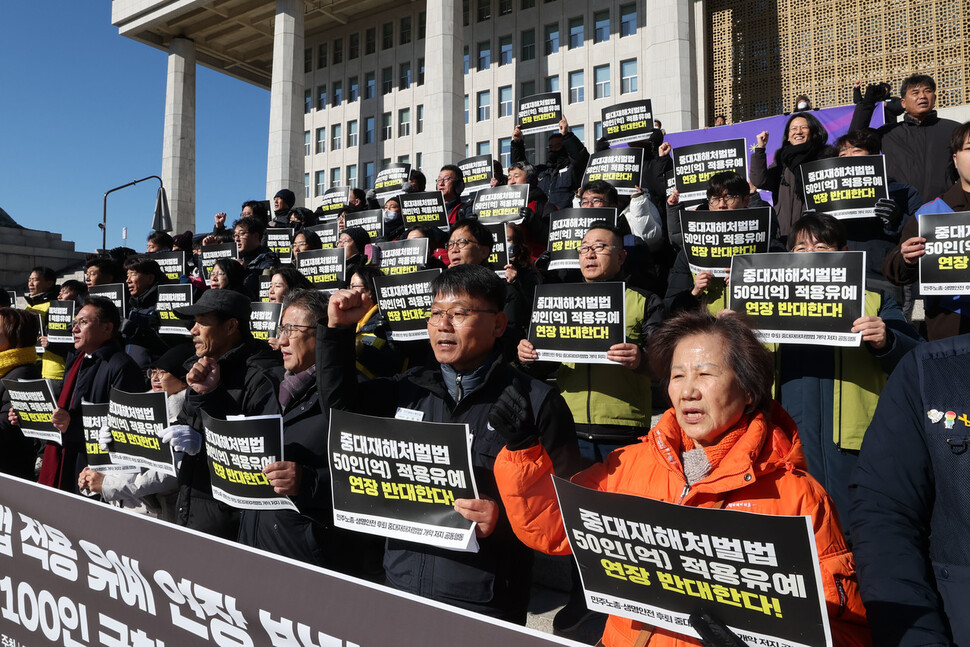 30일 오전 서울 여의도 국회의사당 본청 앞에서 열린 중대재해처벌법 적용 유예 반대 서명 전달 및 100인 국회 기자회견에서 참가자들이 손팻말을 구호를 외치고 있다. 백소아 기자