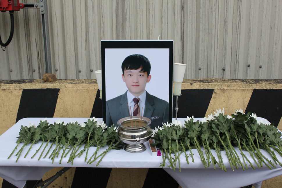 2018년 충남 태안화력발전소에서 끼임 사고로 숨진 청년 비정규직 노동자 고(故) 김용균 씨 5주기인 6일 사고 현장 인근에 마련된 고인의 영정 앞에 추모객들이 헌화한 국화가 쌓여 있다. 연합뉴스