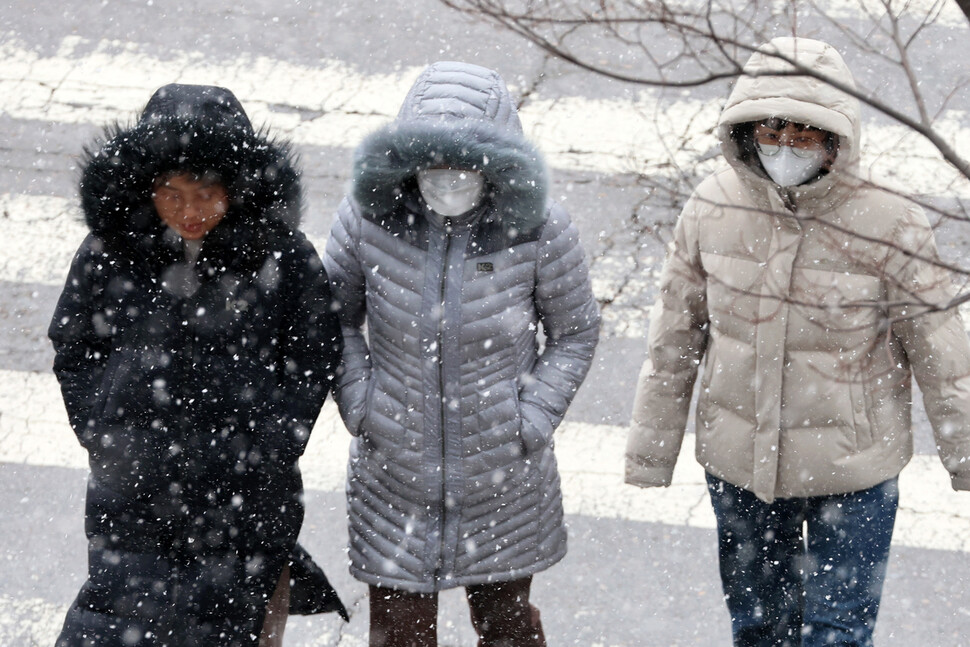 대설주의보와 한파주의보가 내려진 20일 오후 광주 서구 치평동에서 시민들이 내리는 눈을 맞으며 도로를 걷고 있다. 연합뉴스