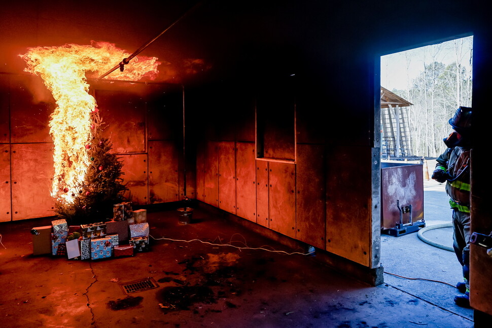 19일 미국 조지아주 마리에타에서 열린 콥 카운티 연말 화재 안전 시연에서 소방관이 크리스마스 트리에 불이 붙는 과정을 모니터링하고 있다. EPA 연합뉴스