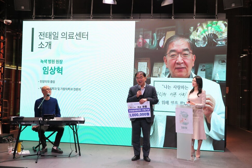 지난 14일 서울 중구 오픈스튜디오에서 열린 ‘우리는 모두 사랑하는 사람을 위해 일을 합니다’(우사일) 콘서트에서 임상혁 녹색병원 원장(가운데)이 전태일의료센터 건립기금 후원에 대한 감사의 뜻을 전하고 있다. 녹색병원 제공
