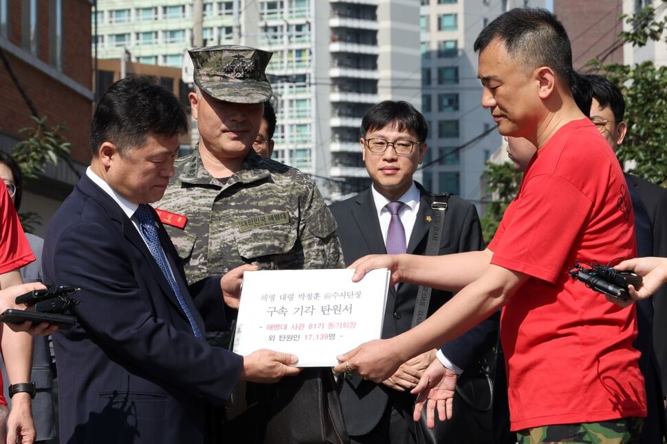 박정훈 전 해병대 수사단장(대령·왼쪽 두번째)의 해병대 동기들이 1일 박 전 단장이 보는 앞에서 해병대 예비역 장병들과 시민 등 모두 1만7139명의 서명이 담긴 구속영장 기각 탄원서를 변호인에 전달하고 있다. 연합뉴스