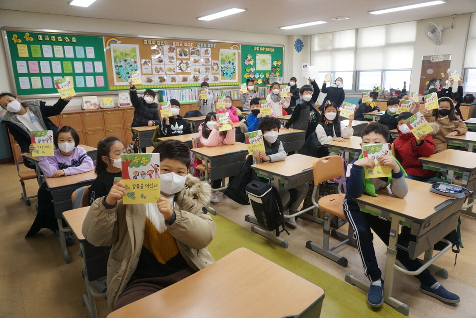 지난 12일 오전, 군산푸른솔초등학교 2학년 4반 어린이들이 자신들이 쓴 시를 엮은 어린이시집 &lt;감꽃을 먹었다&gt;를 들고 있다. 송숙 제공