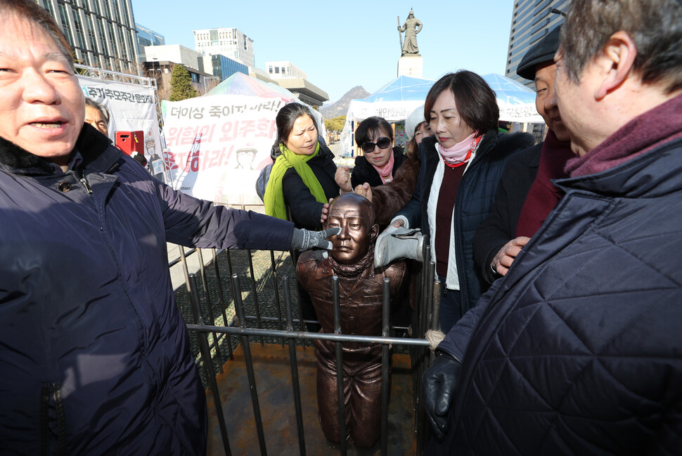 신군부가 일으킨 12·12 군사반란 40주년인 12일 5·18 관련 단체 회원들이 서울 광화문광장에서 전두환 씨의 구속 수사를 촉구하는 기자회견을 한 뒤 이를 상징적으로 표현하기 위해 제작한 동상 조형물을 때리는 행위를 하고 있다. 이종근 기자