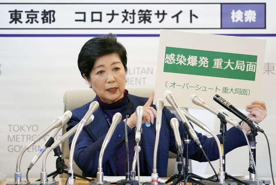 고이케 유리코 일본 도쿄도지사가 지난 3월 긴급 기자회견을 열어 “감염 폭발 중대 국면”이라고 쓴 팻말을 들어 보이고 있다. 민영 방송 뉴스 앵커 출신인 그는 매스컴 활용에 능숙하다. 도쿄/EPA 연합뉴스