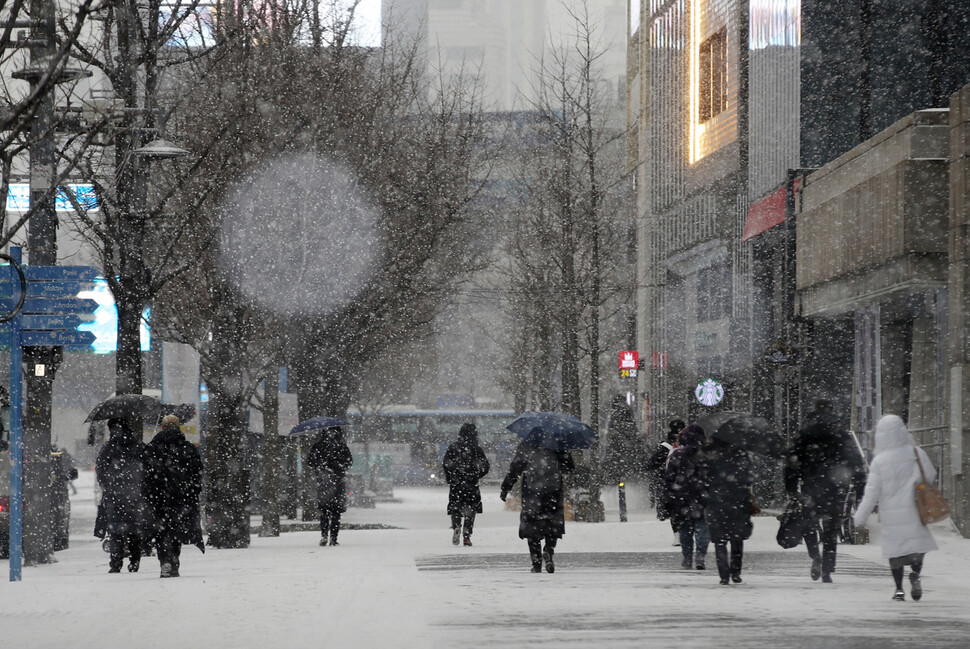 눈이 내리는 서울 세종문화회관 인근에 시민들이 걸어가고 있다. 연합뉴스