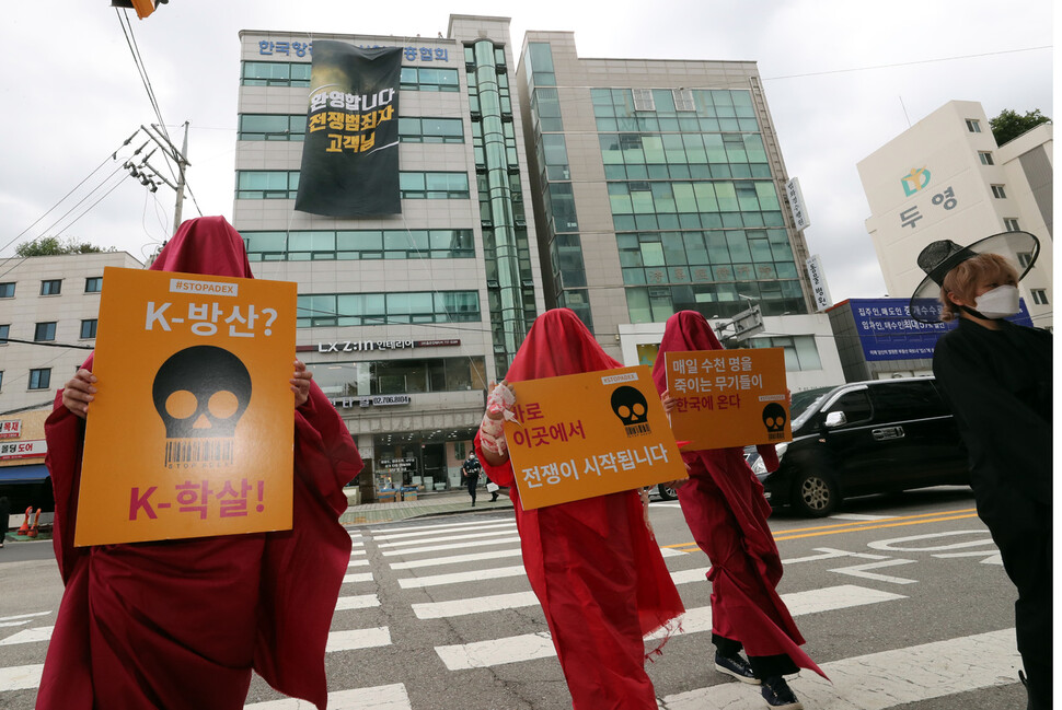 `2021아덱스 저항행동' 활동가들이 5일 오전 아덱스 공동운영본부가 입주해 있는 서울 마포구 대흥동 한국항공우주산업진흥협회 건물 옥상에 아덱스 개최 반대 대형 펼침막을 내건채 전시회 개최 중단 촉구 기습시위를 벌이고 있다. 김태형 기자 xogud555@hani.co.kr