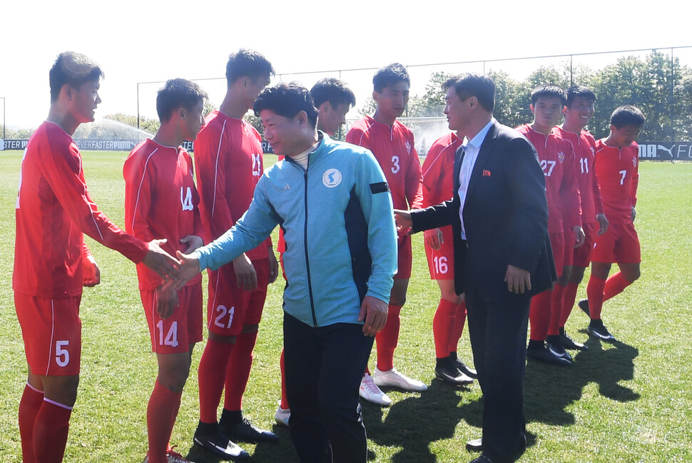 김경성 남북체육교류협회 이사장(왼쪽)과 김기혁 북 4.25체육단장이 2019년 1월 중국 쿤밍에서 열린 강원FC와 북한 4.25 축구종합팀 경기에 앞서 선수들과 악수를 나누고 있다. 남북체육교류협회 제공