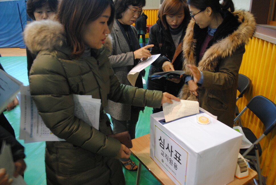 ‘학교경영계획 설명회’가 끝난 뒤 교사 및 학부모들이 ‘교장 공모 채점 기준표’를 작성해 투표함에 넣고 있다.