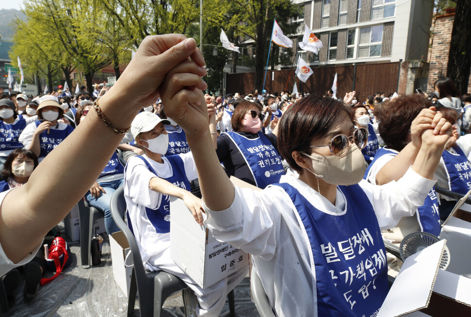 전국장애인부모연대 회원 등 삭발식 및 결의대회에 참석한 시민들이 노래에 맞춰 손을 잡고 흔들고 있다. 김혜윤 기자