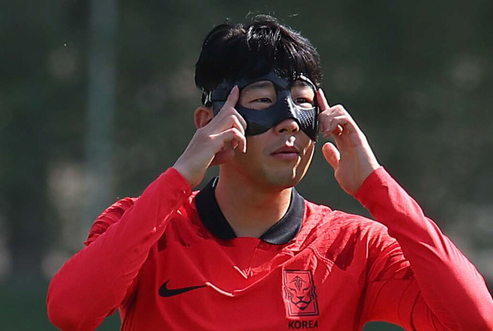 한국 남자축구 대표팀 주장 손흥민(오른쪽)이 16일(현지시각) 오전 카타르 도하 알 에글라 훈련장에서 얼굴 부상 회복을 위해 마스크를 고쳐쓰고 있다. 도하/김혜윤 기자 unique@hani.co.kr