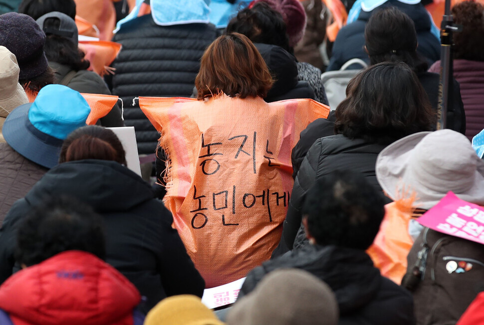 한 참가자가 ‘농지는 농민에게'라고 쓴 쌀자루를 입고 있다. 김혜윤 기자