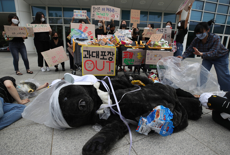 지난 2일 오전 서울 성동구 이마트 성수점 앞에서 녹색연합, 녹색미래 등 환경단체 회원들이 기자회견을 열고 포장 제품의 재포장 금지 제도를 즉각 시행할 것을 촉구하는 퍼포먼스를 하고 있다. 연합뉴스