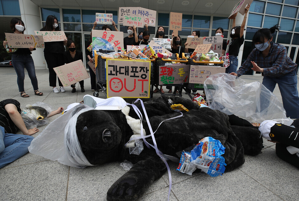 지난 2020년 7월2일 오전 서울 성동구 이마트 성수점 앞에서 녹색연합, 녹색미래 등 환경단체 회원들이 기자회견을 열고 포장 제품의 재포장 금지 제도를 즉각 시행할 것을 촉구하는 퍼포먼스를 하고 있다. 연합뉴스