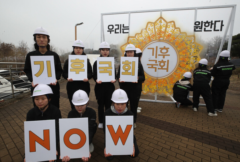 9일 오전 서울 국회의사당 둔치 주차장 인근에서 그린피스 그린뉴딜 시민행동 3기 회원들이 국회 기후위기 대응 촉구하는 ‘기후국회’ 배지 손도장 행위극을 진행하고 있다. 참가자들이 ‘기후국회 나우(NOW)’라고 적힌 손팻말을 들고 있다.