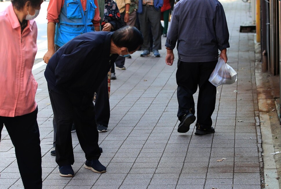 무료도시락을 받기 위해 기다리던 한 노인이 도시락 내용물을 살펴보고 있다. 박종식 기자 anaki@hani.co.kr