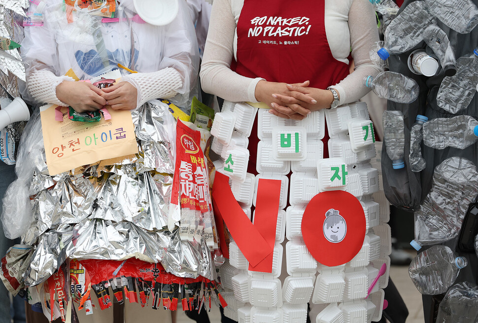 지난해 4월22일 지구의 날 맞아 서울 여의도 한강공원 이벤트광장에서 플라스틱 쓰레기 줄이기 위해 열린 ‘고 네이키드, 노 플라스틱' 캠페인에서 시민 활동가들이 일상에서 배출되는 식품 포장재를 이용해 만든 옷을 입고 있다. 연합뉴스