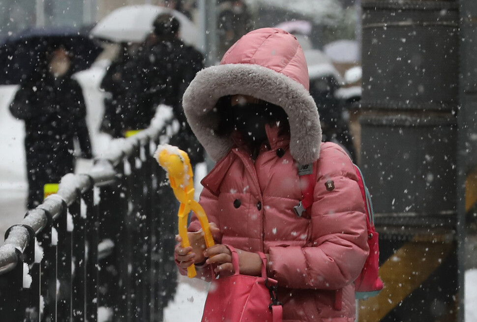 26일 오전 서울 영등포구 영중초등학교 학생이 개학을 맞아 등교하던 중 쌓여있는 눈으로 눈오리를 만들고 있다. 김혜윤 기자