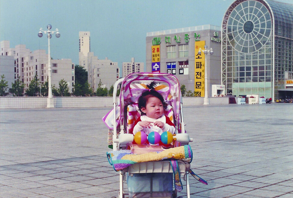 늦둥이이자 무남독녀로 태어난 지은이가 1990년 서울 송파구 올림픽선수촌아파트 상가 광장에서 유모차를 타고 있는 모습을 어머니가 촬영했다. 마민지 제공