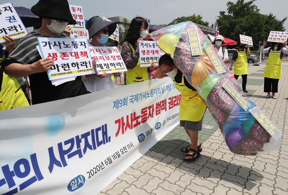 가사노동자들이 16일 제9회 국제가사노동자의날을 맞아 서울 영등포구 국회의사당 앞에서 열린 기자회견에서 코로나19로 고통받는 가사노동자를 표현한 행위극을 하고 있다. 백소아 기자