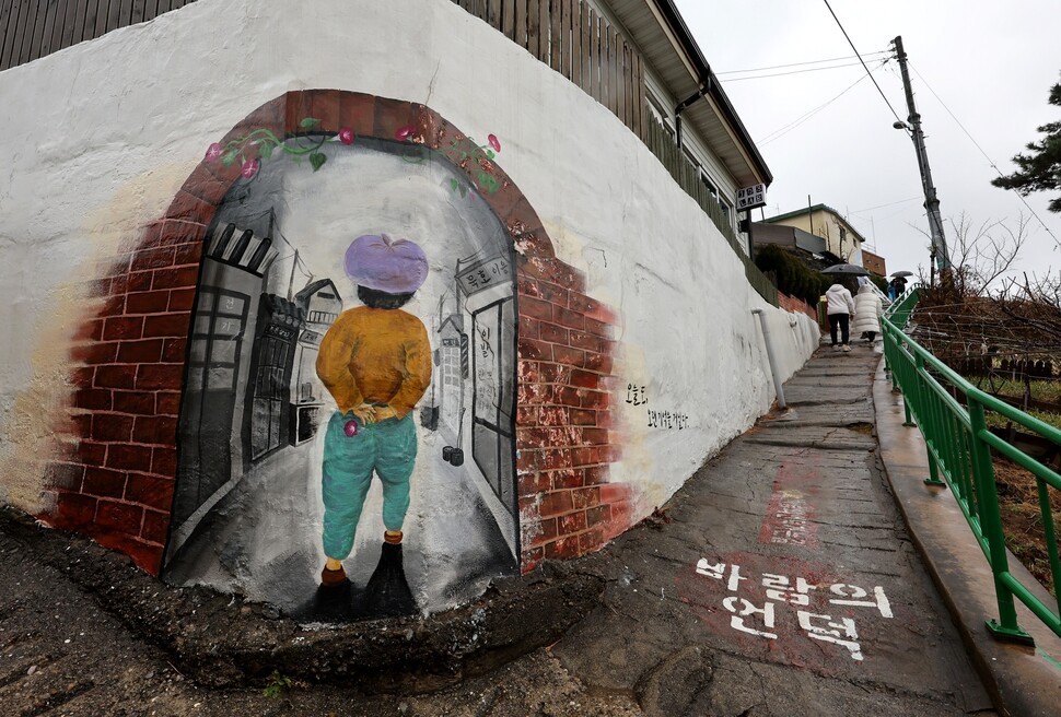 논골담길&nbsp;‘바람의&nbsp;언덕’으로&nbsp;탐방객들이&nbsp;올라가고&nbsp;있다.&nbsp;이곳에선&nbsp;벽화를&nbsp;담에&nbsp;그렸다&nbsp;해서&nbsp;‘담화’라&nbsp;부른다.