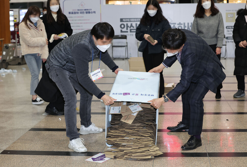 5일 오후 서울역에 차려진 사전투표소에서 관계자들이 관외투표함을 열고 있다. 연합뉴스