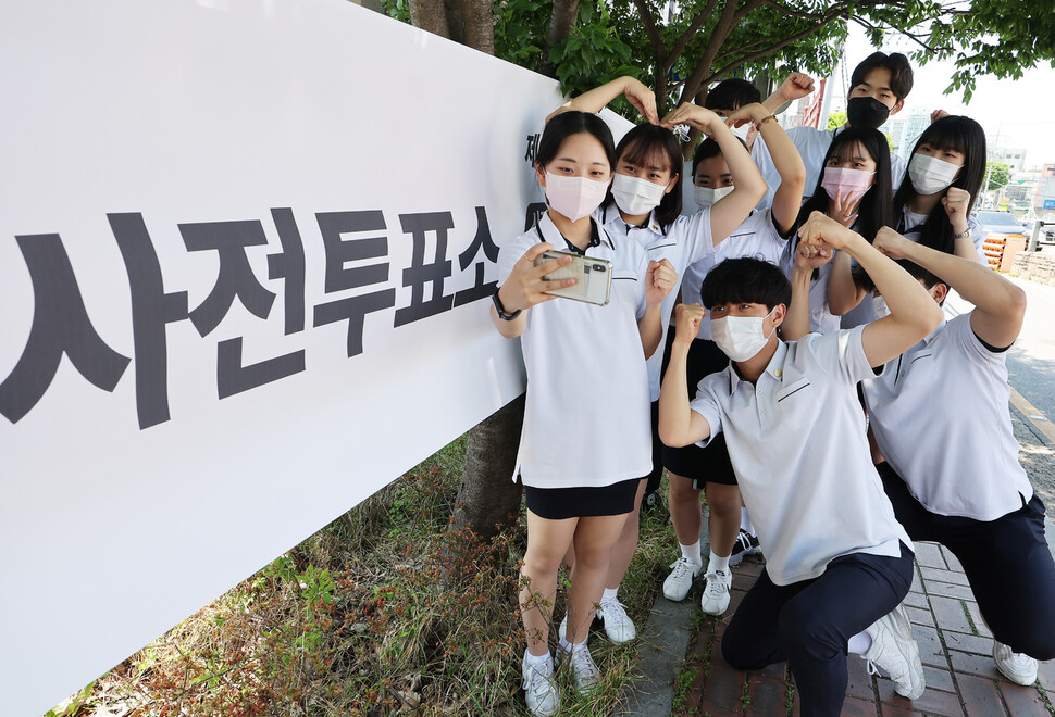 제8회 전국동시지방선거 사전투표 첫날인 27일 오후 경기도 수원시 장안구 연무동행정복지센터에 마련된 투표소에서 투표를 마친 삼일공업고등학교 3학년 학생들이 더운 날씨에 가벼운 옷차림으로 인증샷을 찍고 있다. 연합뉴스